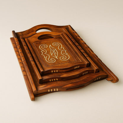 A set of three handcrafted wooden serving trays with rustic finish, stacked on top of each other, featuring intricate designs on the larger tray.